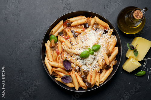 Penne pasta with eggplant, tomatoes and parmesan cheese. Traditional italian food