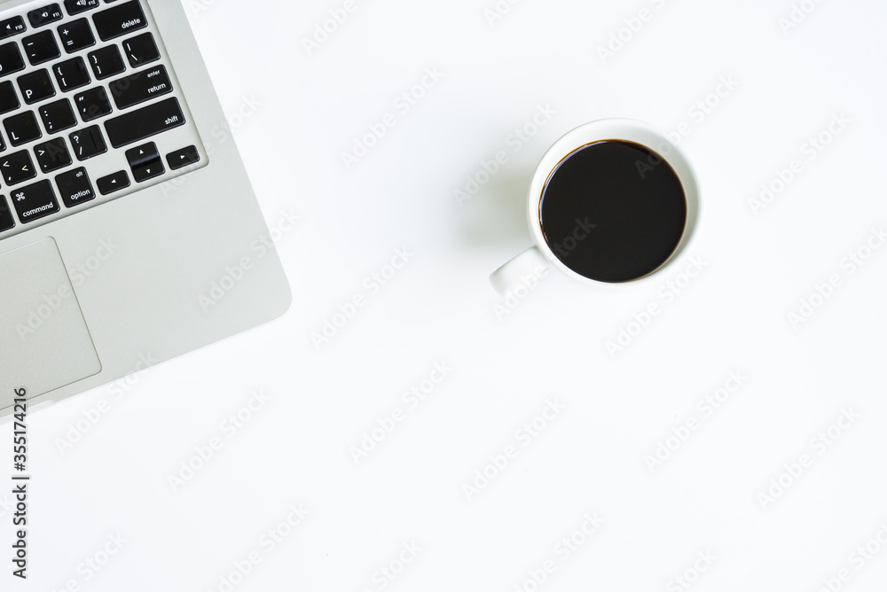 White office desk table with laptop computer, cup of black hot coffee White office desk table with laptop computer, cup of black hot coffee