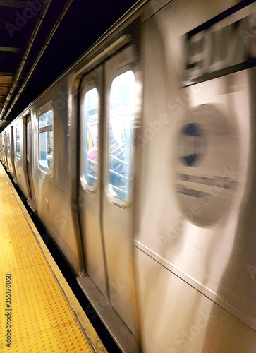 Train speeding up in New York City subway station. arrive or depart. Motion blur effect. photo