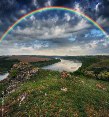 colorful rainbow over river canyon