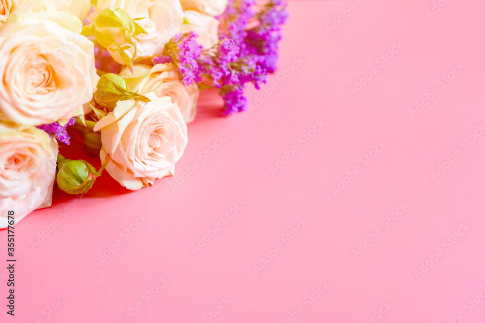 a bouquet of cream roses and bright purple flowers in full bloom on a pink background with space for text. greeting card. flare a bouquet of cream roses and bright purple flowers in full bloom on a pink background with space for text. greeting card. flare
