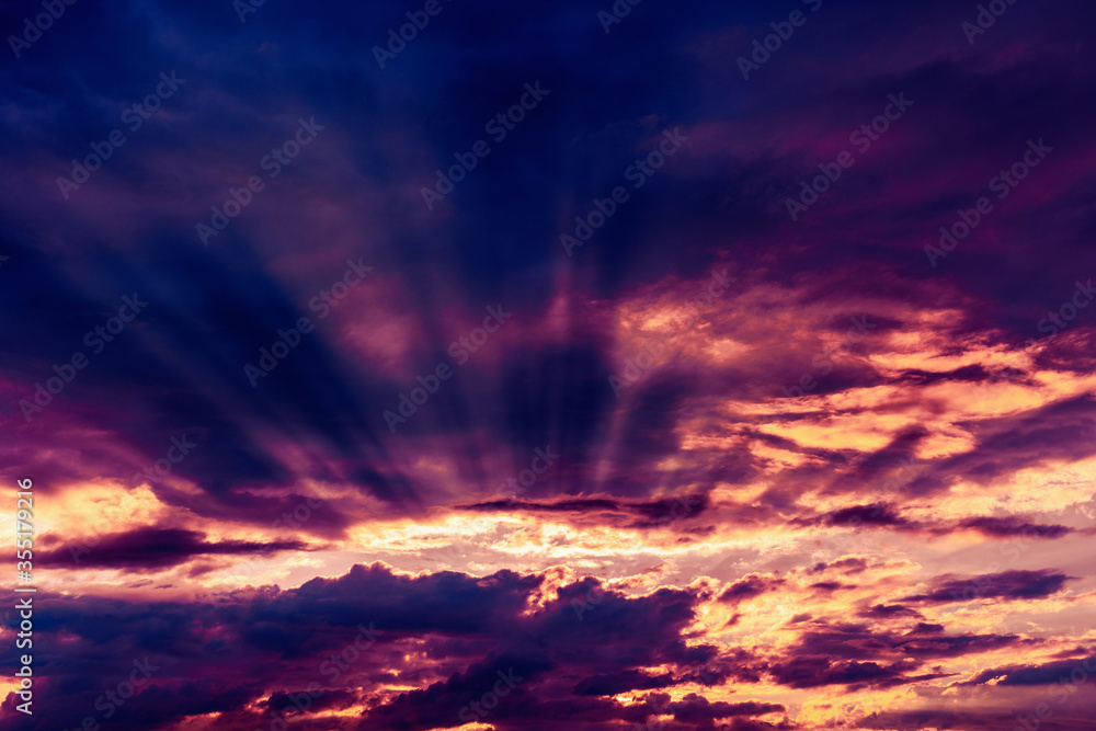 Fototapeta premium Dramatic sky with sunbeams breaking through the clouds