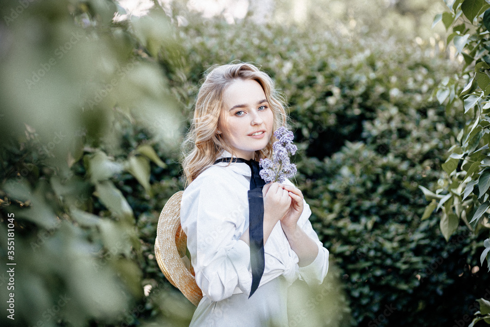 Summer Sunny lifestyle Portrait of a young stylish blonde in a Park, dressed in a cute fashionable dress and a straw hat. Summer Sunny lifestyle Portrait of a young stylish blonde in a Park, dressed in a cute fashionable dress and a straw hat.