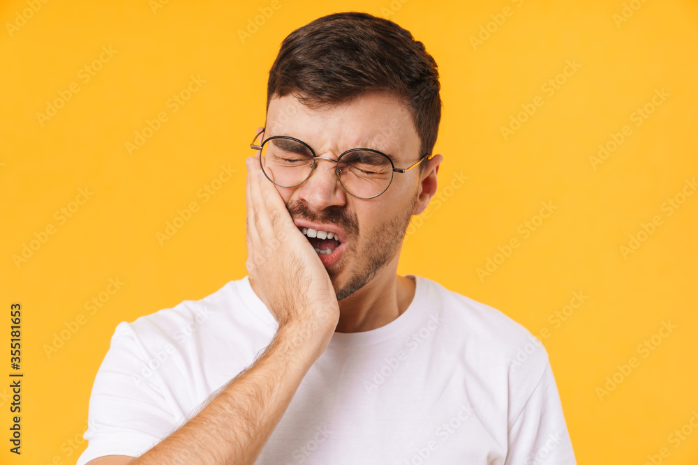 Photo of unhappy young man in eyeglasses with toothache Photo of unhappy young man in eyeglasses with toothache