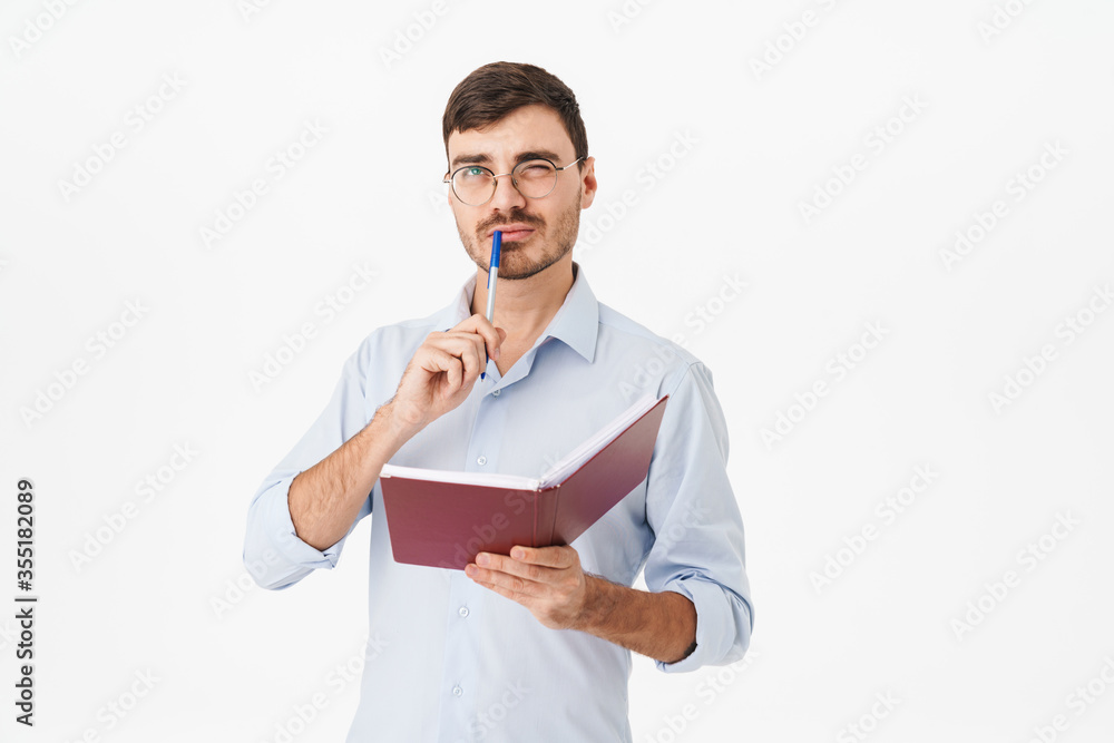 Photo of thinking handsome man in eyeglasses making notes in diary Photo of thinking handsome man in eyeglasses making notes in diary