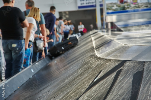 moving conveyor belt with suitcases at baggage claim at airport.