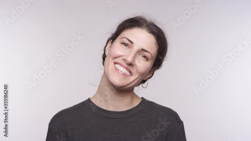 Portrait of a beautiful middle aged woman of Spanish smiles wide and shakes her head in slow motion