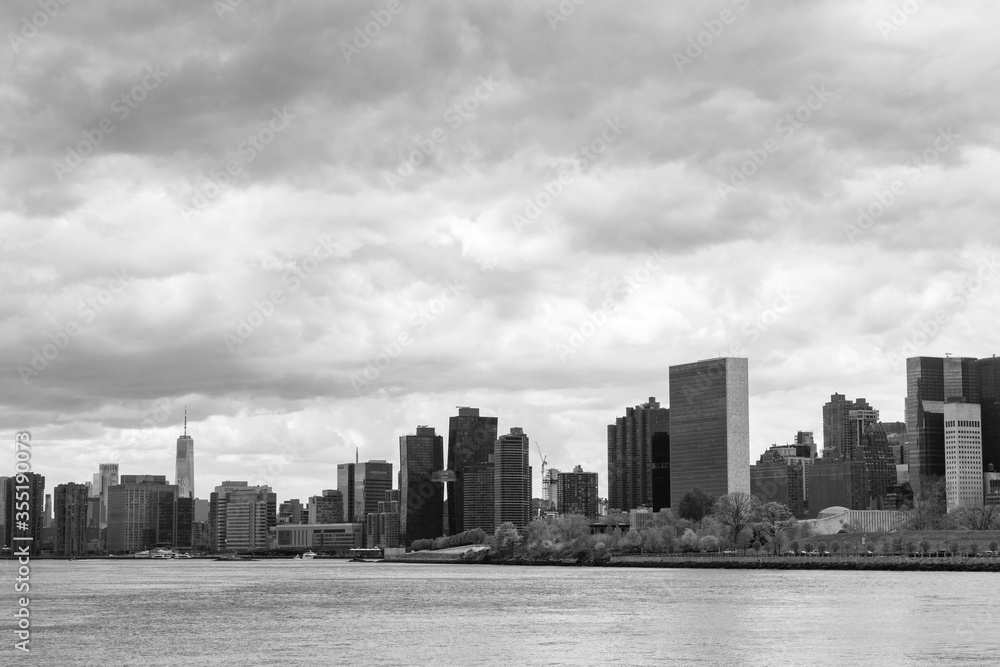 Black and White Manhattan Skyline along the East River in New York City with a Cloudy Sky Black and White Manhattan Skyline along the East River in New York City with a Cloudy Sky