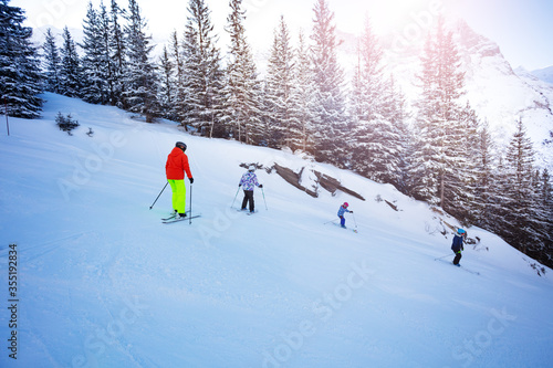 Group of kids on the mountain ski down in school formation
