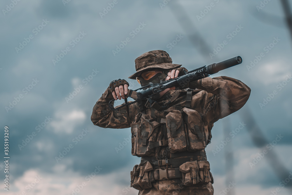 Fototapeta premium Russian soldier with a rifle against the sky. Mobilization