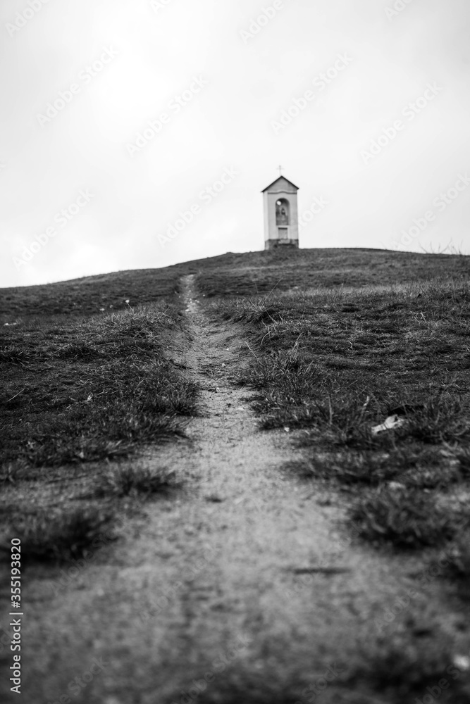 Small black and white chapel on hill