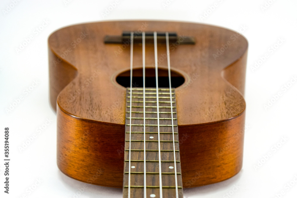 Brown ukulele guitar on isolated white background. holiday relax break time with music concept. Brown ukulele guitar on isolated white background. holiday relax break time with music concept.