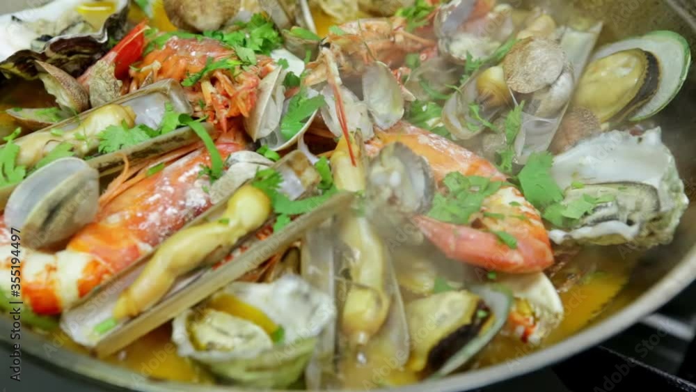 Cooking a cataplan, a Portuguese dish, with organic, clean seafood on fire. Horizontal video. Close-up. Cooking a cataplan, a Portuguese dish, with organic, clean seafood on fire. Horizontal video. Close-up.