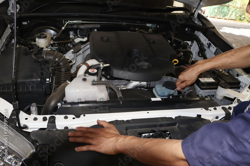 The mechanic is checking the engine.