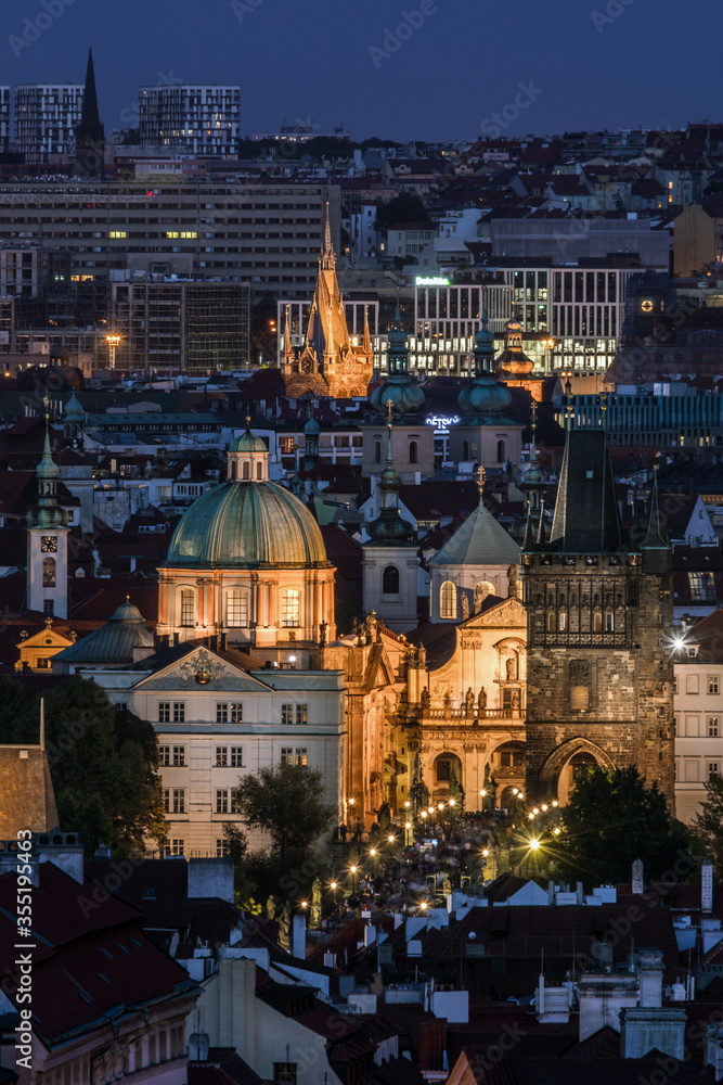 Fototapeta premium View of the centre of Prague and Charles Bridge in the evening with night illumination. Tourism. Towers of Prague. Czech Republic