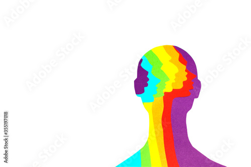 The gender neutral silhouette of a person within which rainbow-colored profiles are cut out of paper. The paper art photo was made on a white background. There is a place for text.