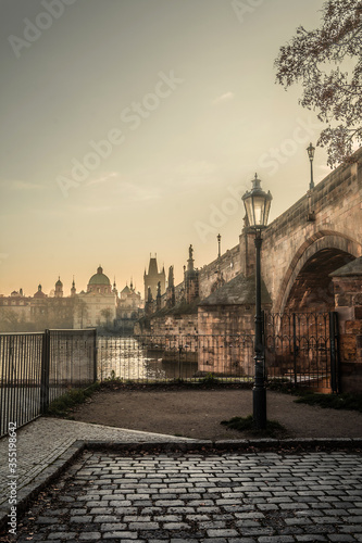 Foggy Charles Bridge in Prague with in the morning. Lantern in the foreground. Travel. Prague.