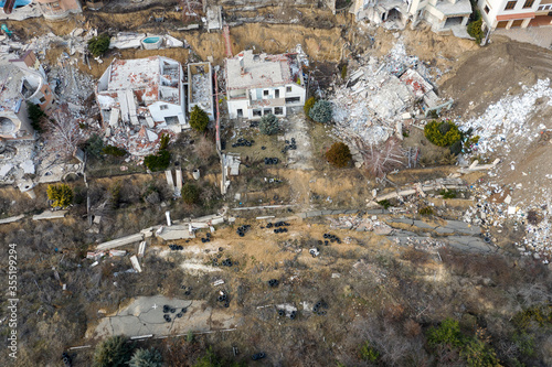 Landslide caused by rains of hurricane destroyed expensive cottages and houses. Destroyed house, cottage, large cracks, chips, slabs. Broken asphalt shifted landslide after earthquake. View from drone photo