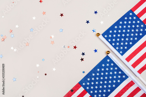 Festive background with US flags and confetti in the shape of stars. US independence day concept.