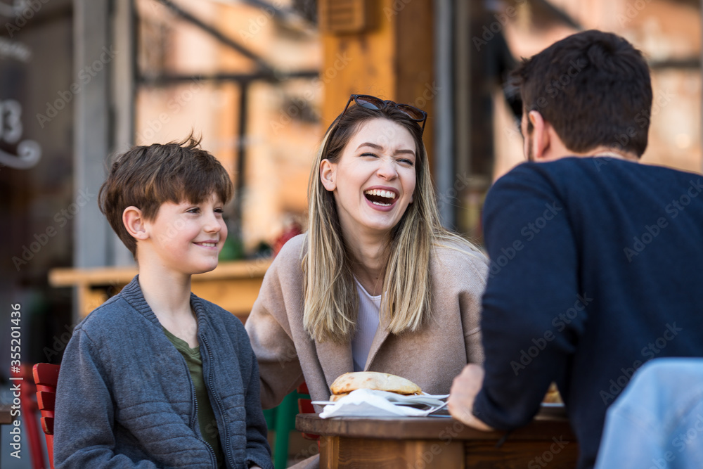 Family of three enjoying their time outside in a restaurant