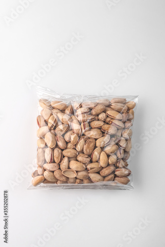 food photography of clean transparent plastic pistachios pack top view on a light gray background isolated close up 