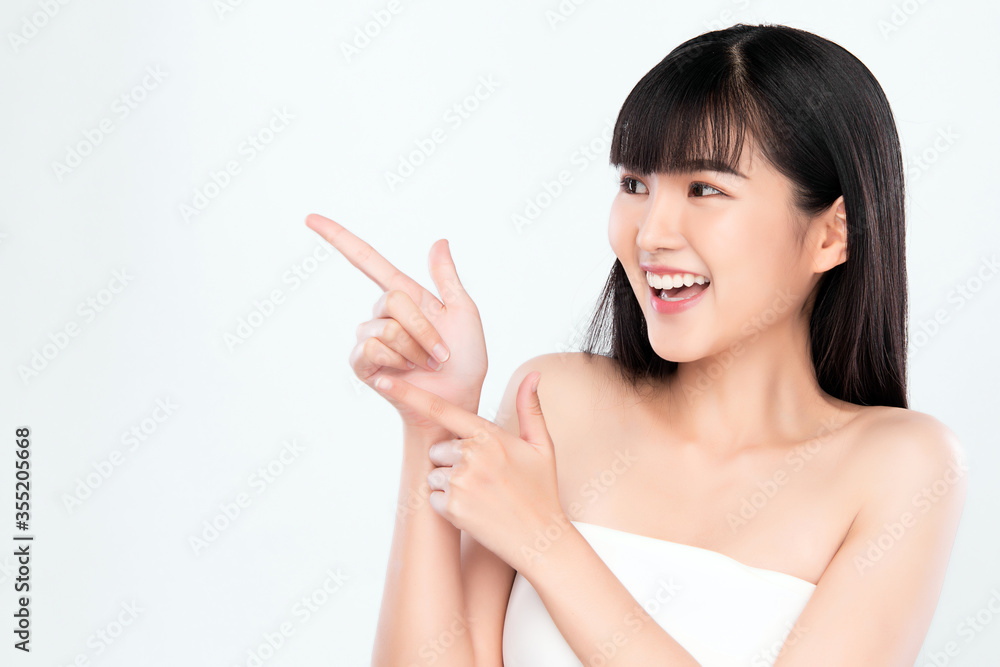 Beautiful young Asian women smile and pointing to copy space for display Cosmetics product feeling happiness with Healthy Clean and Fresh Skin,Isolated on white background, Beauty Concept Beautiful young Asian women smile and pointing to copy space for display Cosmetics product feeling happiness with Healthy Clean and Fresh Skin,Isolated on white background, Beauty Concept