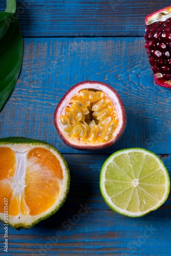 Passion fruit, tangerine and lime on the blue wooden background