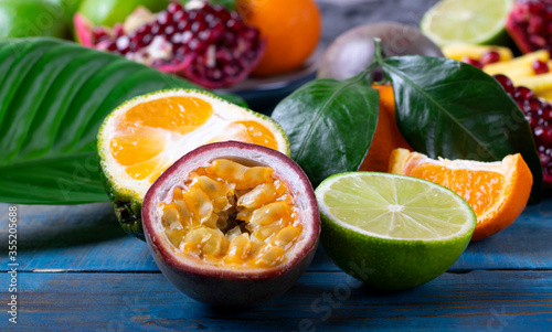 Passion fruit, tangerine and lime on the blue wooden background