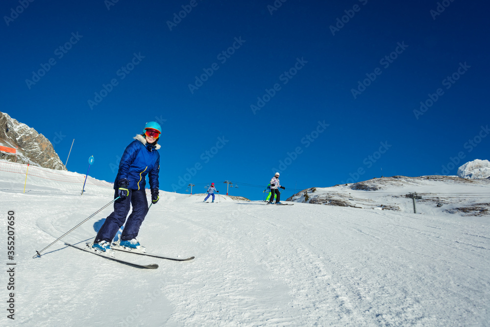 Happy teenager ski on the hill with friends portrait, sunny day on Alpine mountain resort