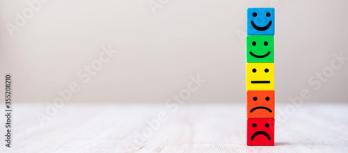 Tableau sur toile Emotion face symbol on yellow wooden cube blocks