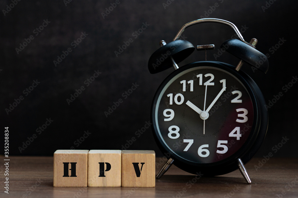 HPV word on wood cube block with black clock, conceptual HPV word on wood cube block with black clock, conceptual