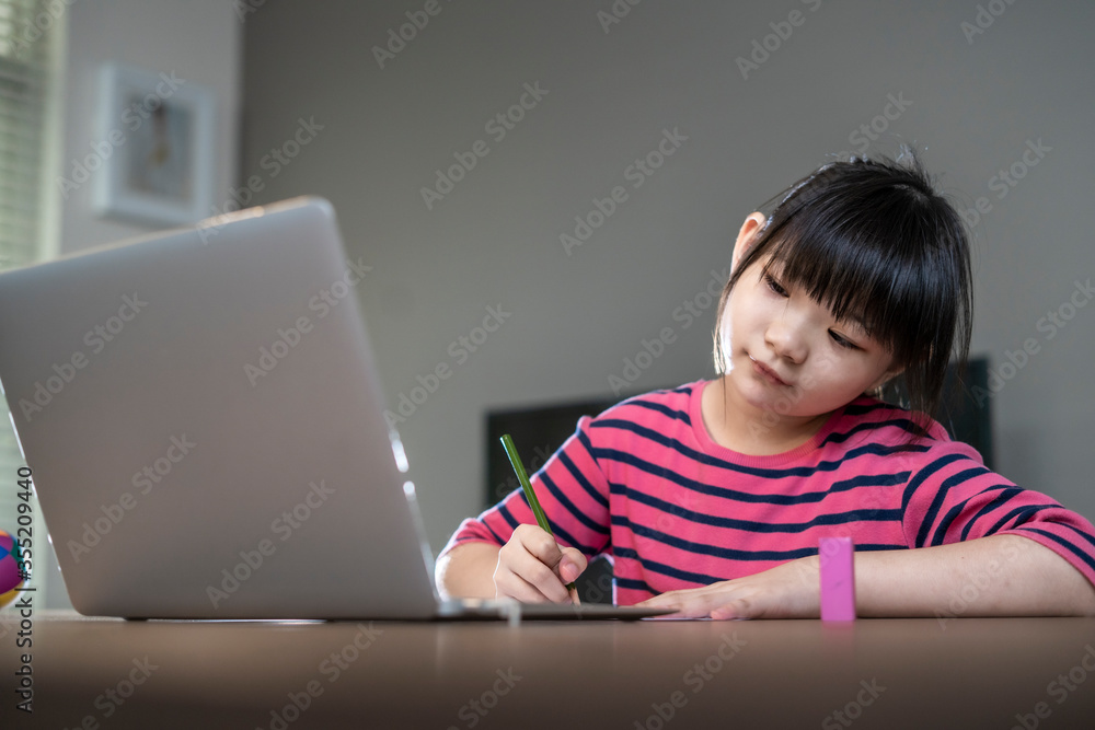Asian girl student online learning in class study.Online video call with teacher.Child girl eating rice congee breakfast with laptop at home.New normal.Covid-19 coronavirus.Social distancing.stay home Asian girl student online learning in class study.Online video call with teacher.Child girl eating rice congee breakfast with laptop at home.New normal.Covid-19 coronavirus.Social distancing.stay home