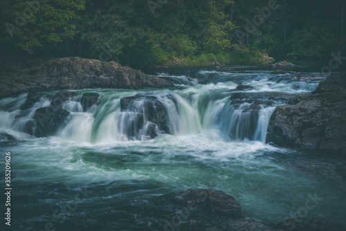 Fototapeta Naklejka Na Ścianę i Meble -  Beautiful flowing waterfall through lush forest in Washington State, Pacific Northwest, United States