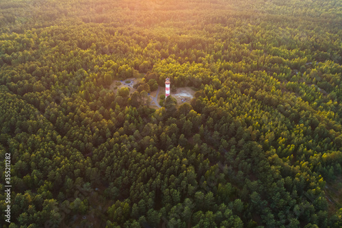Evening aerial view of lighthouse surrounded by vegetation in Curonian spit near Nida, Lithuania