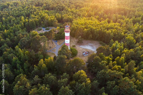 Evening aerial view of lighthouse surrounded by vegetation in Curonian spit near Nida, Lithuania