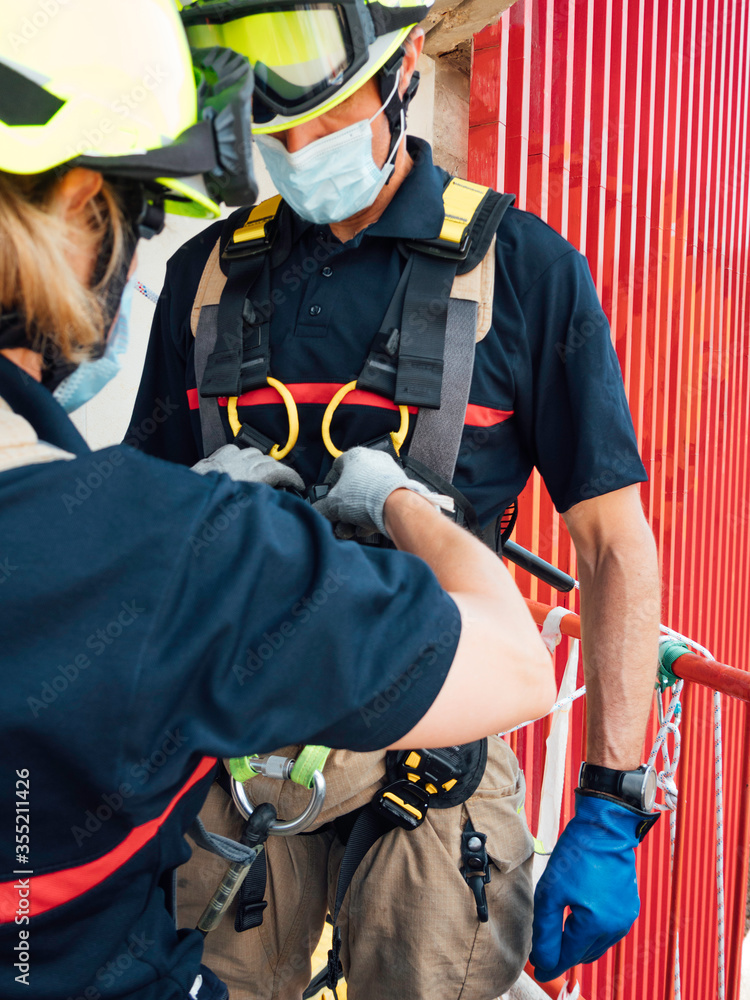 Firefighters reviewing tools in vertical rescue practices during a training exercise Rescue concept Firefighters reviewing tools in vertical rescue practices during a training exercise Rescue concept