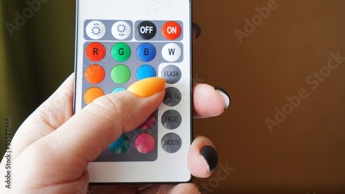 Remote control for change colors in hand on blurred background