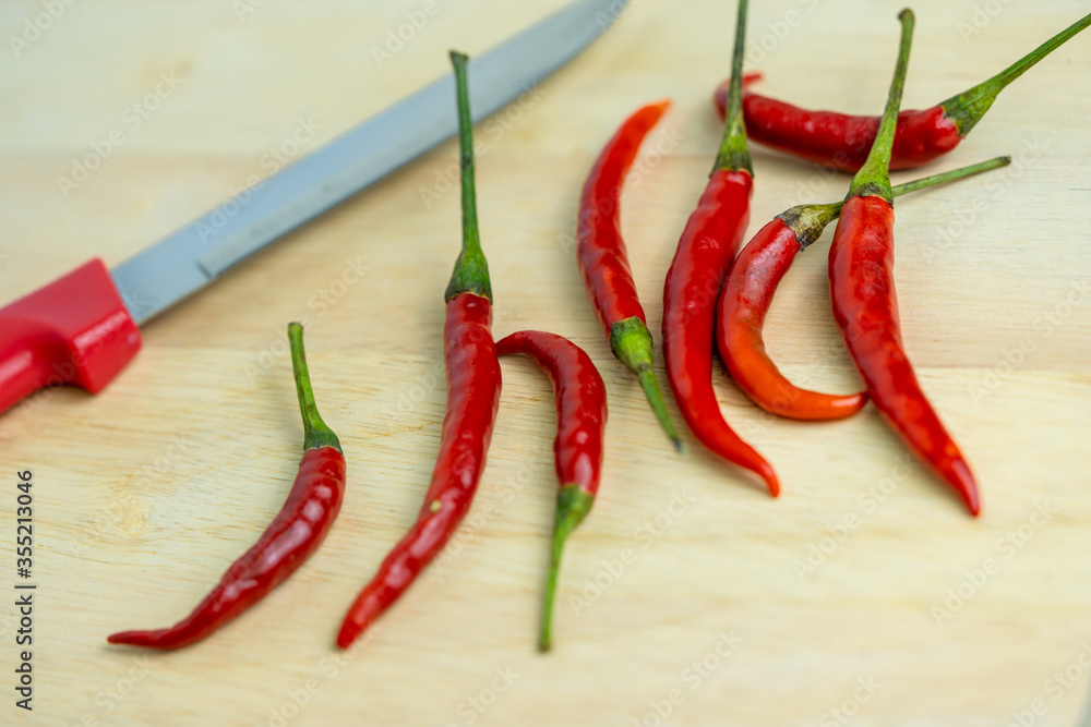 Close-up of chilli and red knives on a wooden floor, meat, fresh food ingredients concept Close-up of chilli and red knives on a wooden floor, meat, fresh food ingredients concept