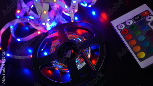 LED strip in purple colors and a control panel for switching colors. Dark background photo