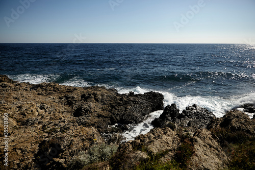 Sea view from a shore. Wave on a rock. 
