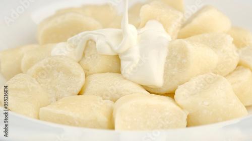 lazy cottage cheese dumplings with greek yogurt in white plate. closeup