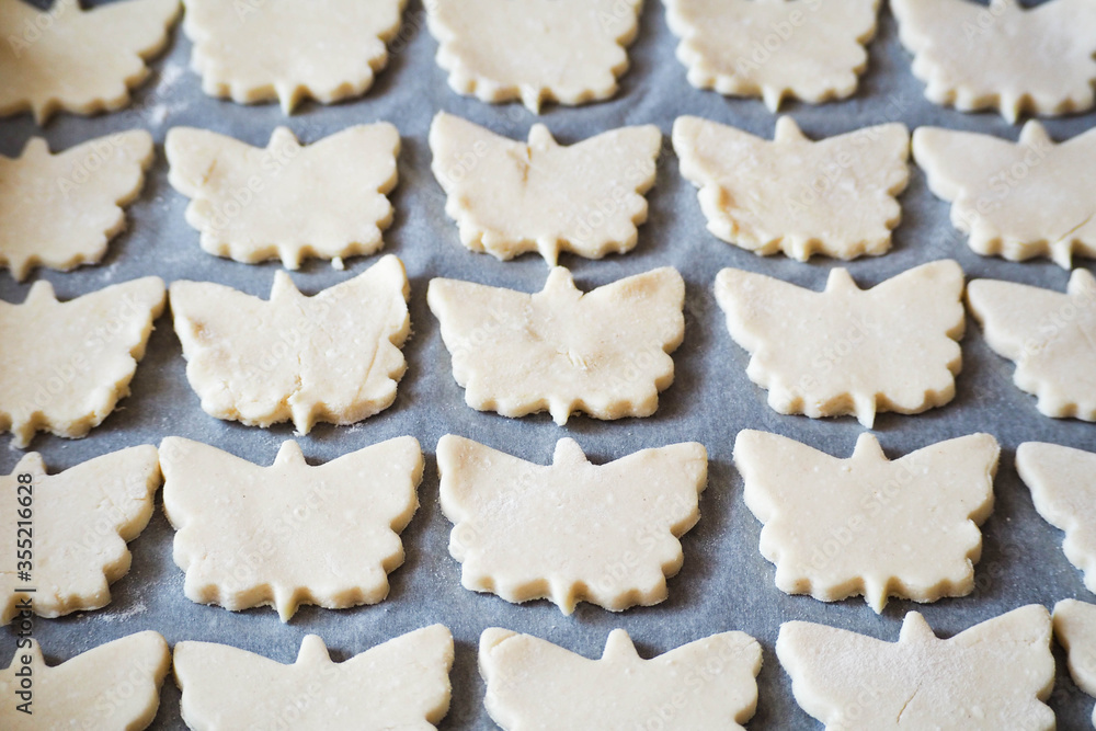 raw gluten-free cookies lie symmetrically on parchment paper in the form of butterflies made of cottage cheese and rice flour . raw cookies before baking raw gluten-free cookies lie symmetrically on parchment paper in the form of butterflies made of cottage cheese and rice flour . raw cookies before baking