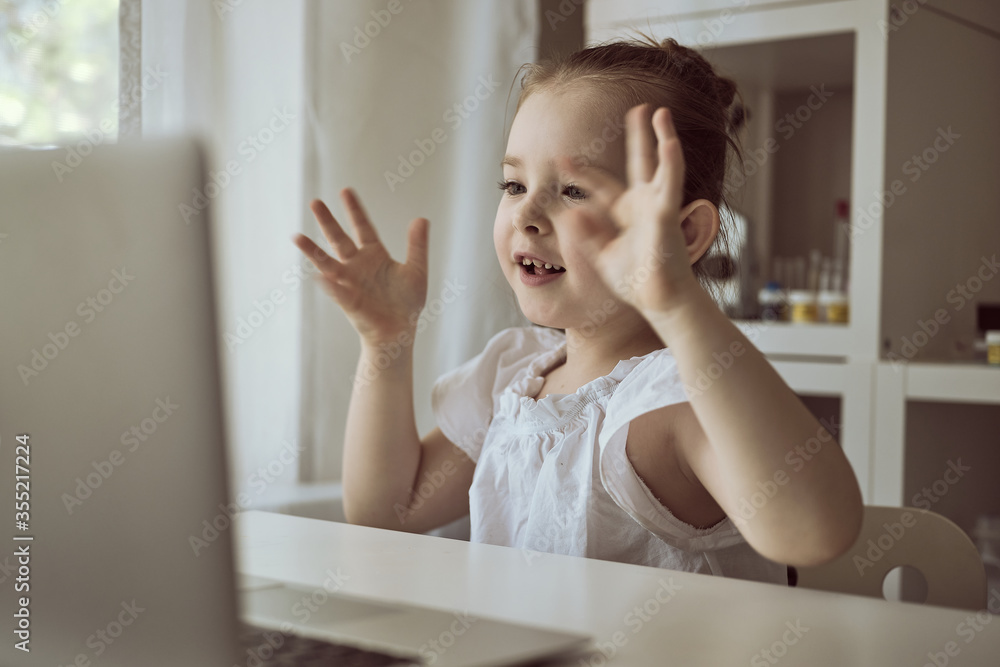 Cute little girl using laptop at home. Education, online study, home studying Kids distance learning Cute little girl using laptop at home. Education, online study, home studying Kids distance learning