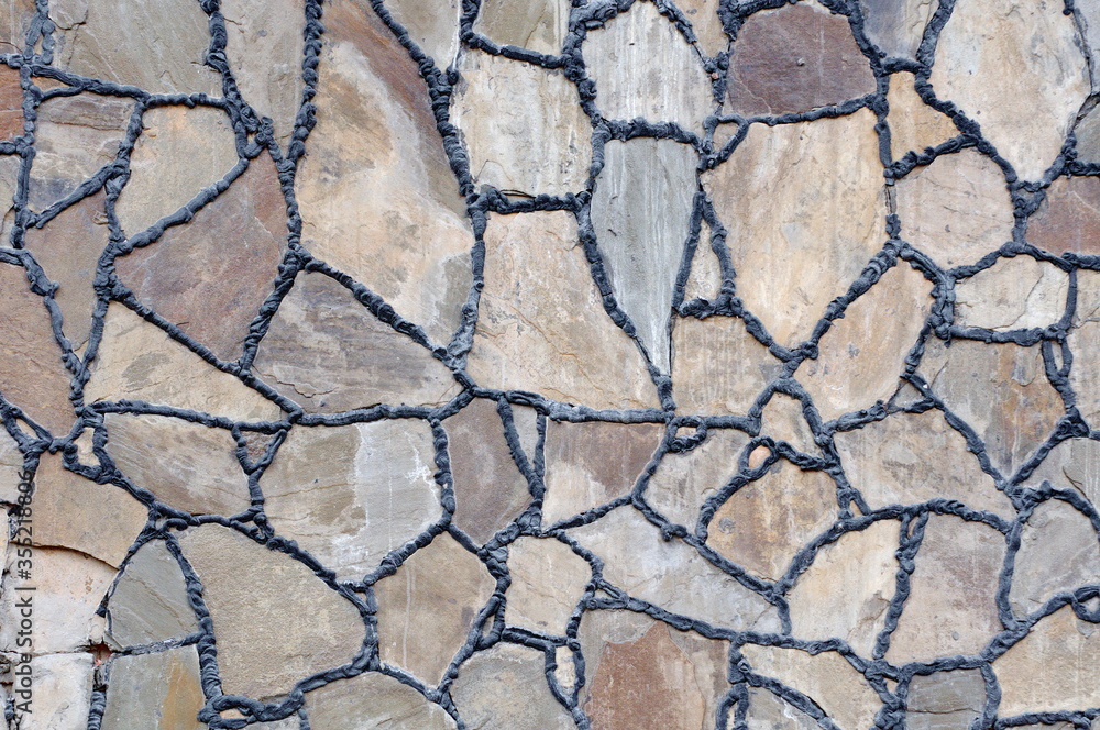 Obraz premium Laying tiles of natural stone on the wall of the guest house. Moscow region. Russia.