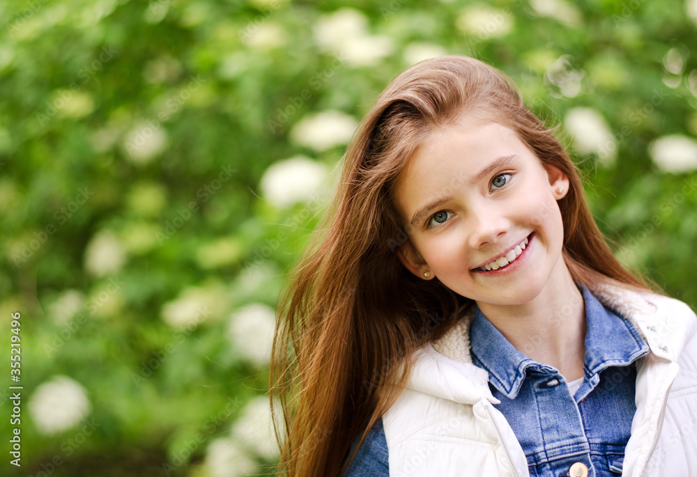 Portrait of adorable smiling little girl child pre teen in the park outdoors