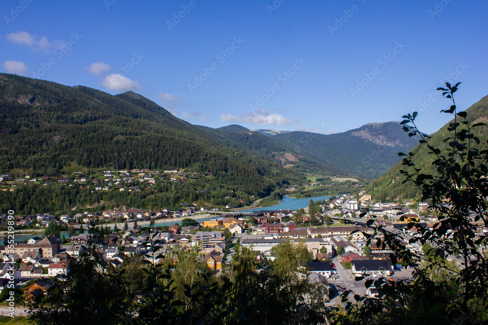 View of a mountain valley with a river below and houses. Norway. Otta