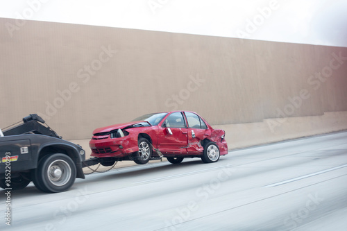 Fototapeta Naklejka Na Ścianę i Meble -  totaled car being towed on highway