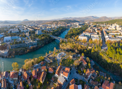 Confluence of Ribnica and turquoise Moraca river, flowing through downtown Podgorica in Montenegro on a sunny afternoon. Old town (Stara Varos) with red roofs. 