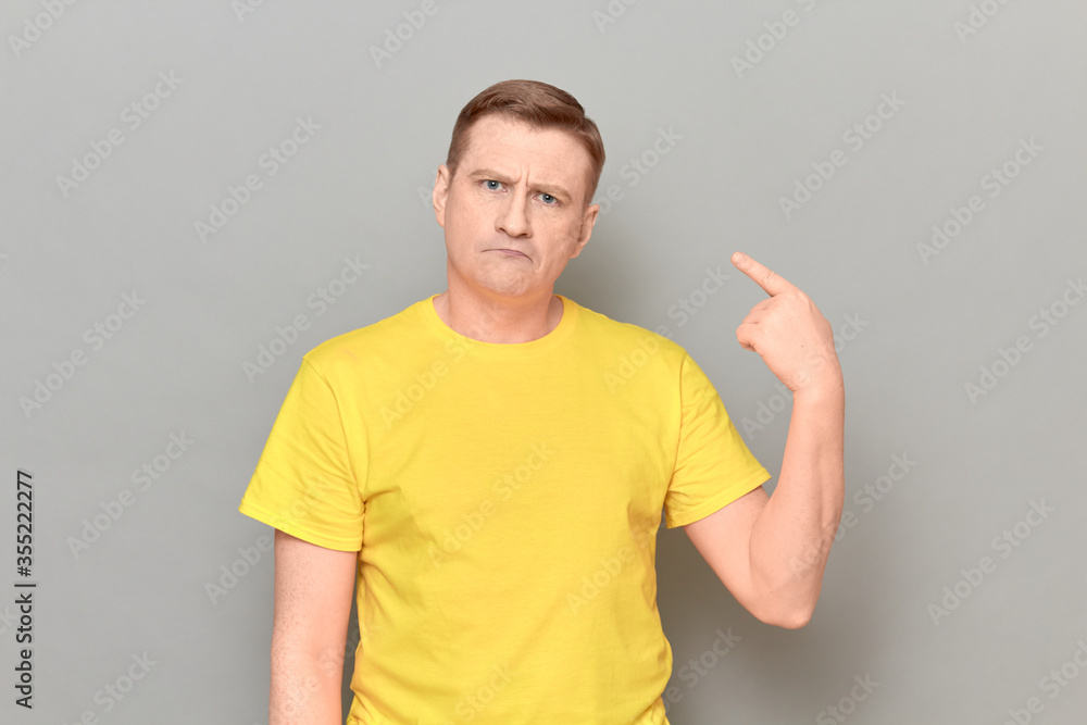 Fototapeta premium Portrait of funny proud man pointing with index finger at himself