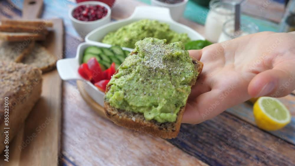 Salting An Avocado Toast In A Hand For Healthy Breakfast. Salting An Avocado Toast In A Hand For Healthy Breakfast.